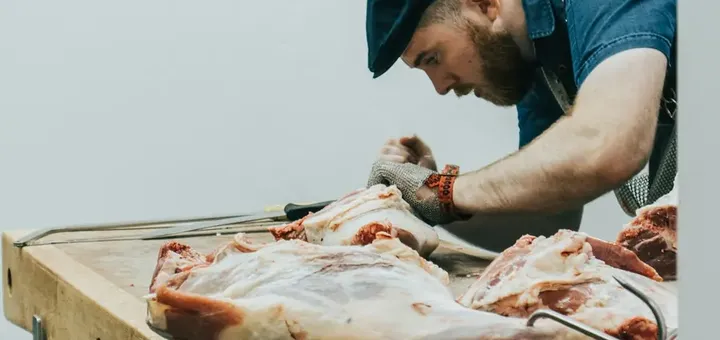 Carnicero cortando carne en el mostrador